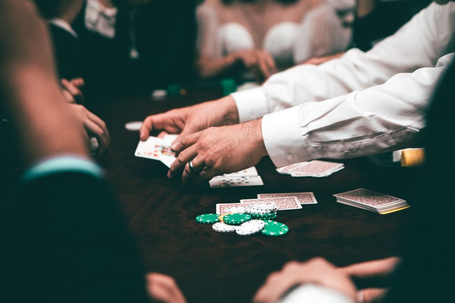 Kartu remi dan chip poker di atas meja hijau